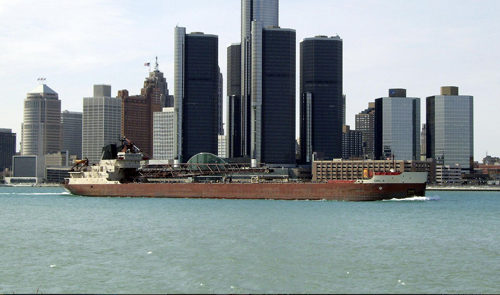The Detroit skyline, with a large cargo ship in front of the buildings.