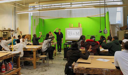 A man leads the students in the maker space