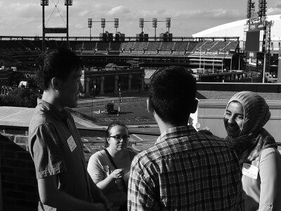 Black and white photo of interns conversing amongst each other outside in the sun